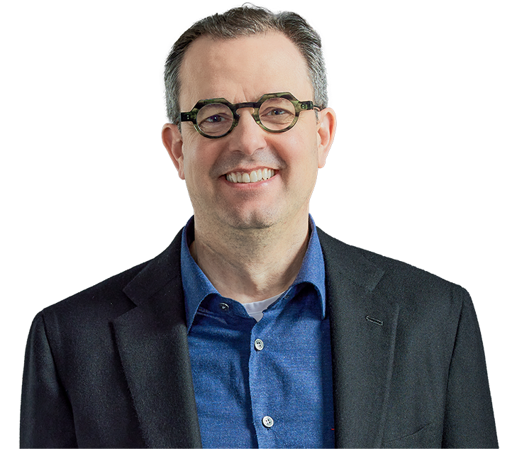  A headshot of a smiling man with short brown hair and glasses wearing a blue button-down shirt.