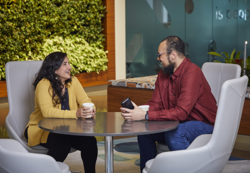 Two people are sitting at a table having a conversation.